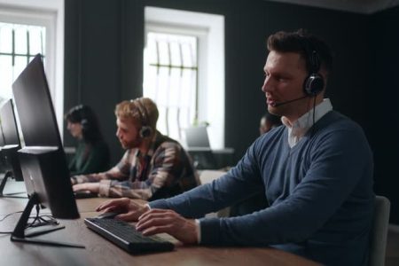 round-the-clock call-center, portrait of male technical support specialist consulting customers by phone calling, telemarketing and telesales